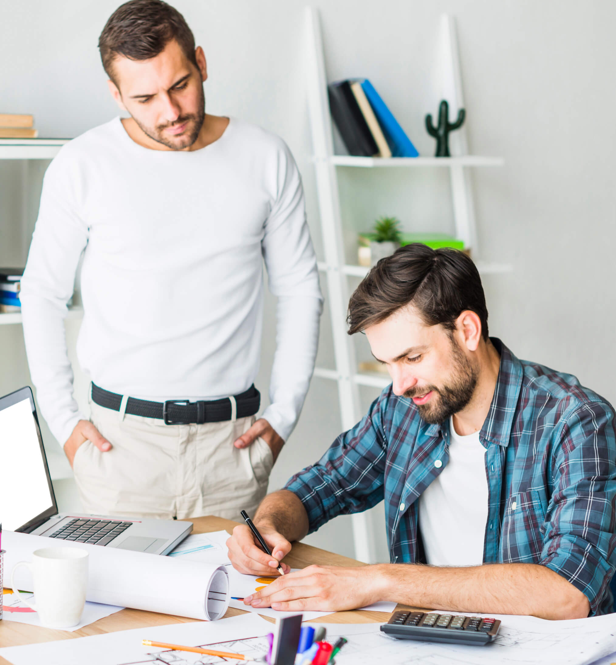 Two men working on a project at a desk.